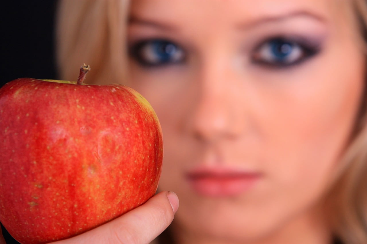 femme tenant une pomme à la main